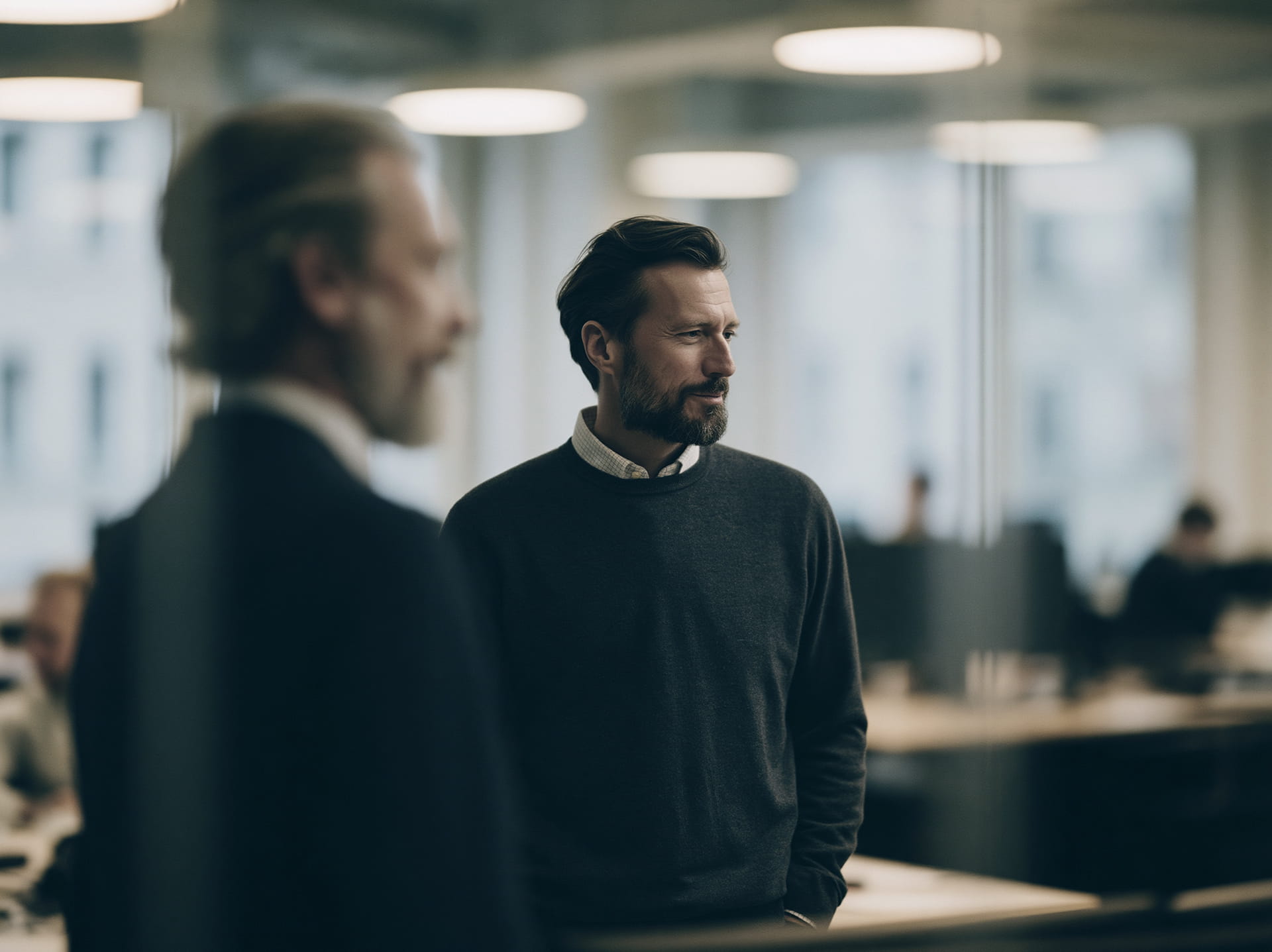 Två kollegor i ett svenskt kontor som samtalar.